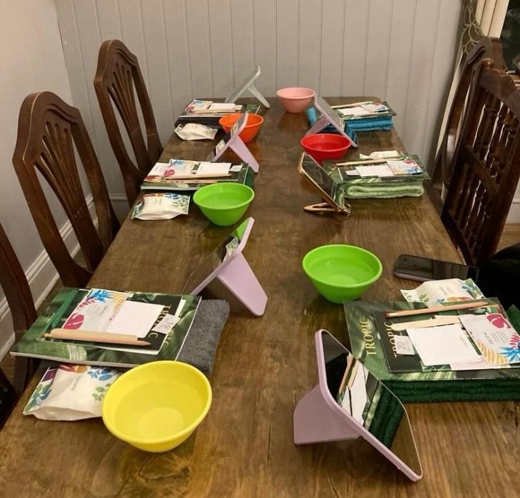 A Tropic skincare workshop table set up with colourful mixing bowls, product brochures and treatment tools ready for guests